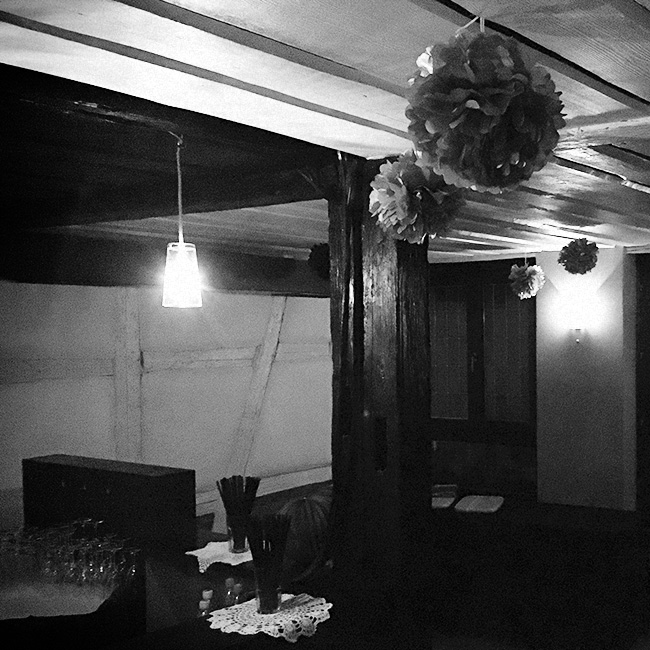 Raum mit Fachwerk, Holzdecke und Papier-Pompons
